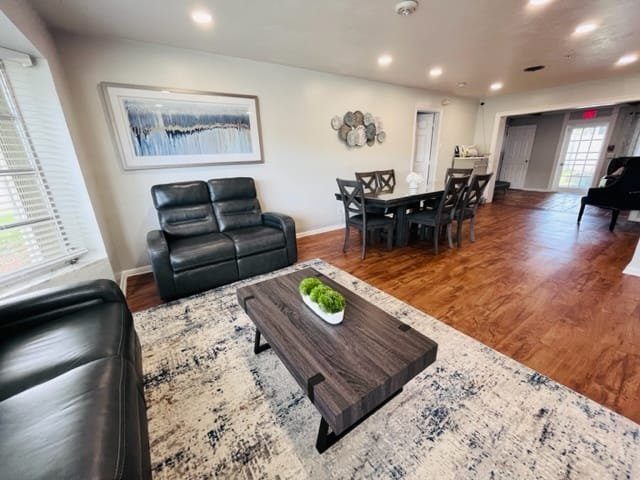 Living room with leather seating, a coffee table and a dining table beyond at a Serenity Living home